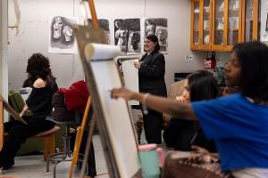 Drawing students study the human figure during a studio session, exploring composition, shading, and expression. 