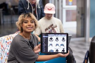 A Digital Studies student presenting digital artwork and design concepts using a tablet, showcasing hands-on creative development.