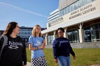 Stockton University students walk outside the John F. Scarpa Academic Center, home to learning spaces that support programs across campus.