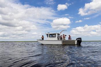 Marine Science students conduct fieldwork aboard a research vessel, collecting data in coastal waters near Stockton University.