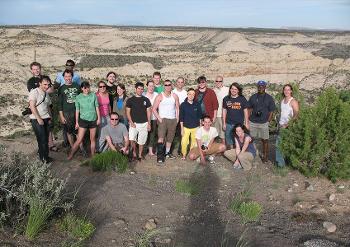 Stockton University geology students conduct fieldwork in a desert landscape, studying rock formations and geologic processes in the field.