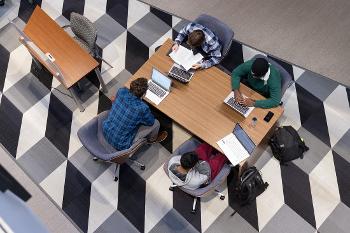 Accounting students collaborate in a modern study space while reviewing coursework in auditing, taxation, and financial management.