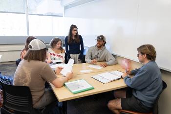 Teacher Education students at Stockton University collaborate in a small-group classroom setting focused on lesson planning and communication skills.