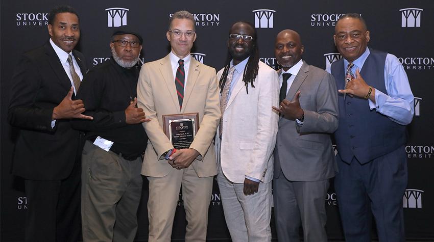 John Cash, Jr. '91 and his fraternity brothers posing with his award