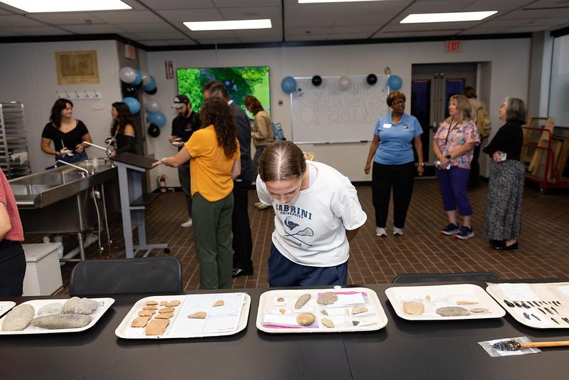 A archaeology student examining recovered artifacts