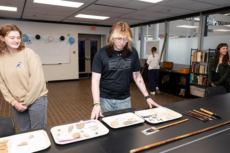 Archaeology students examining recovered artifacts