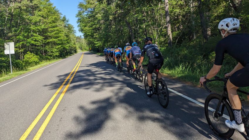 Cyclists riding safely on the shoulder of the course.