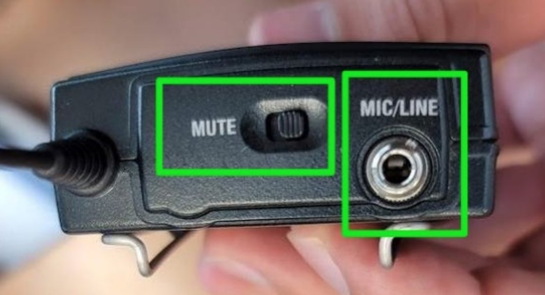 a picture of the top of a wireless microphone transmitter, with indicators highlighting the mute switch and the microphone input
