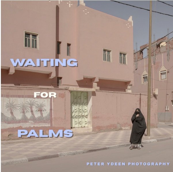 A photograph featuring a person in a black abaya and niqab standing on a sidewalk in front of a pink building, with the overlaid text "WAITING FOR PALMS" and "PETER YDEEN PHOTOGRAPHY."