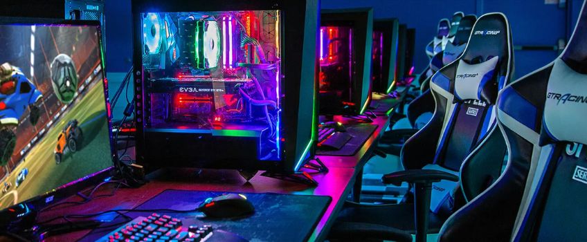 Stockton University ESports Lab - gaming chairs facing computers with colorful neon mood lighting