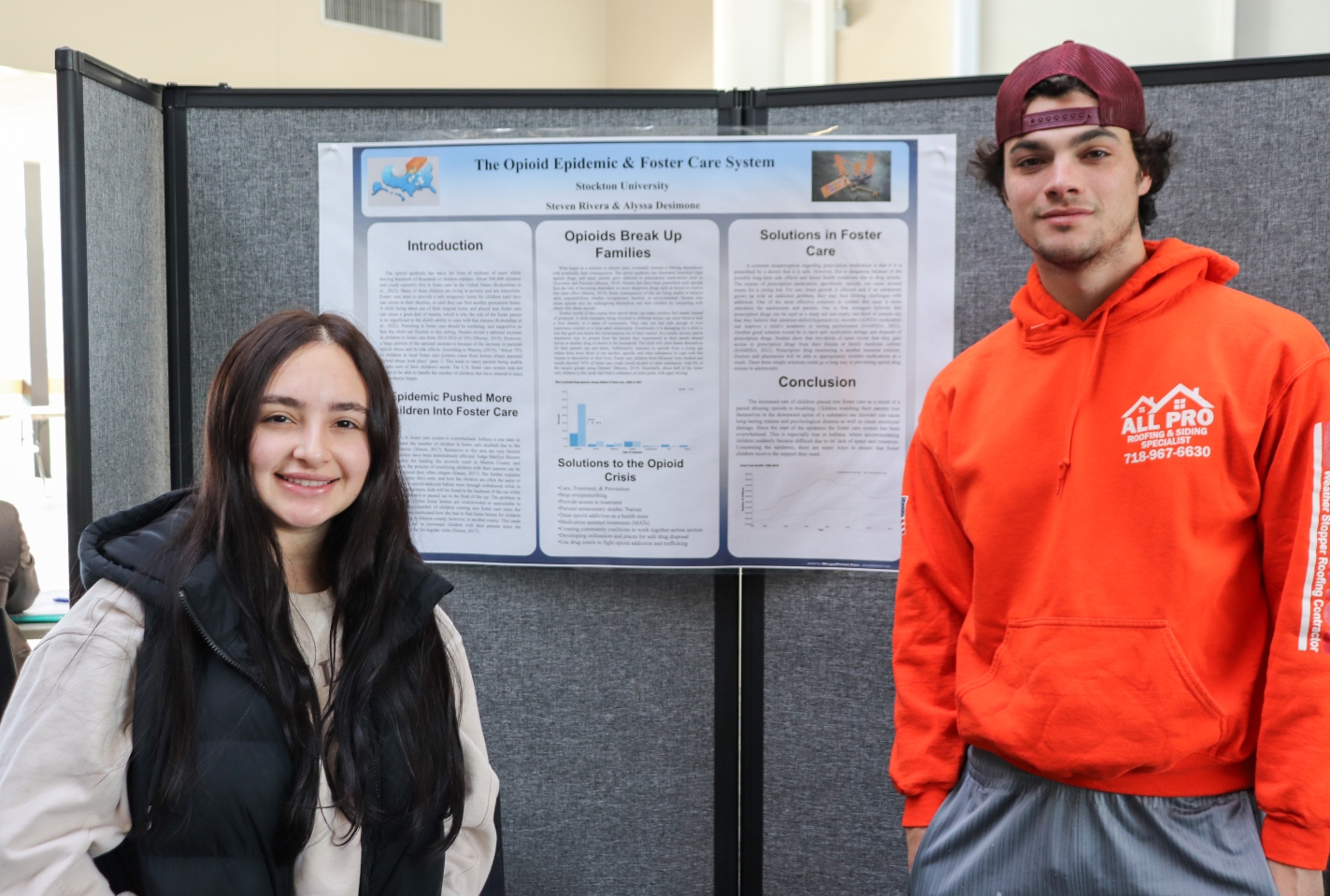 Alyssa Desimone and Steven Rivera stand in front of their project poster.