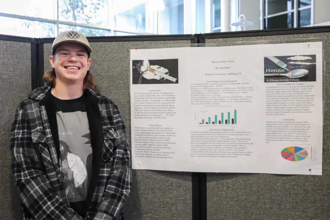 Izen Small stands in front of his poster about heroin overdoses in New Jersey.