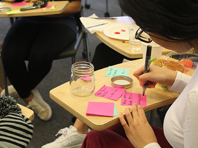 A Stockton student writing notes of inspiration for inspiration jars