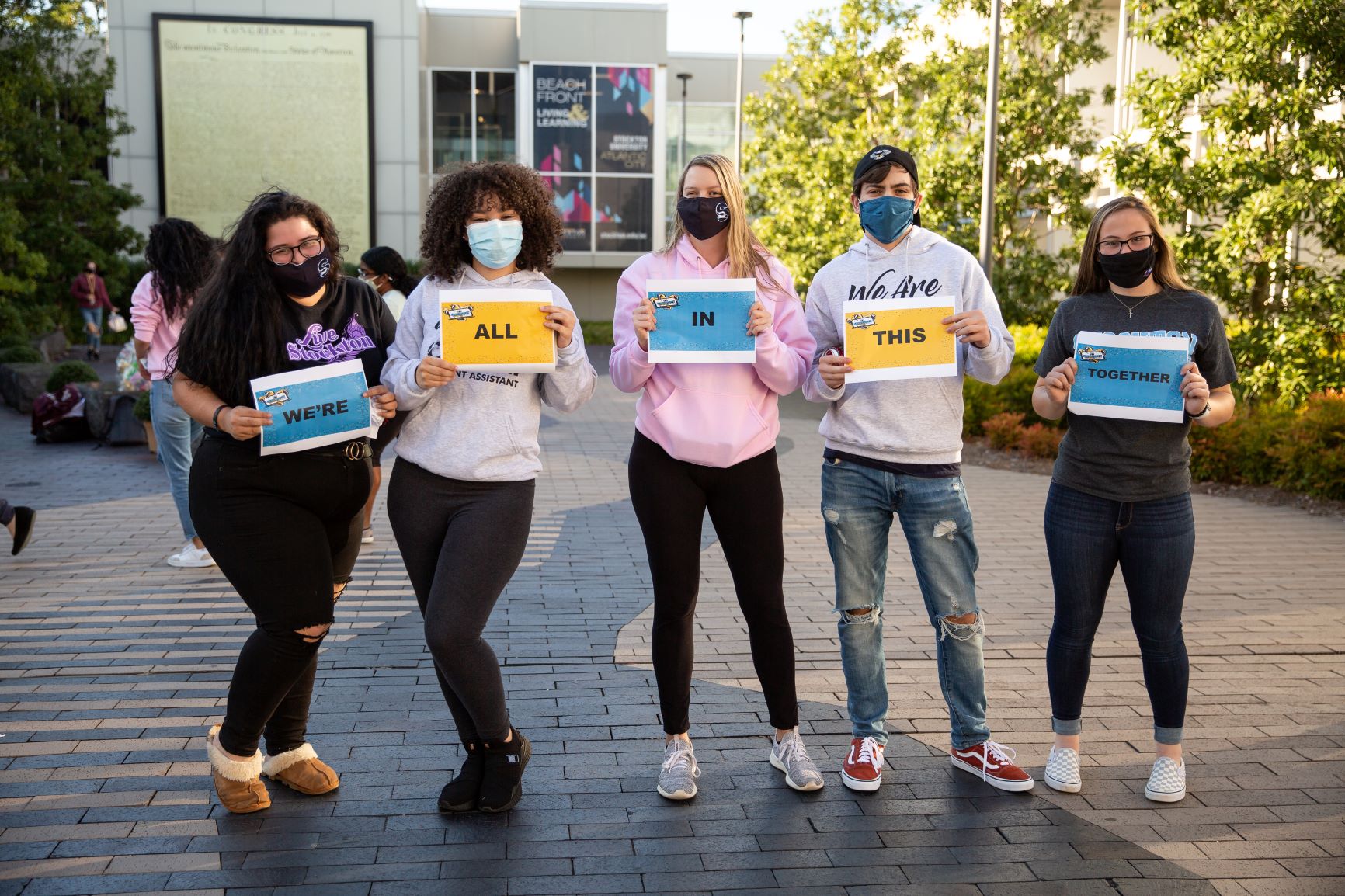 Resident Assistants spell out "We're In This Together" on signs during The Happening Flash Mob in October 2020.