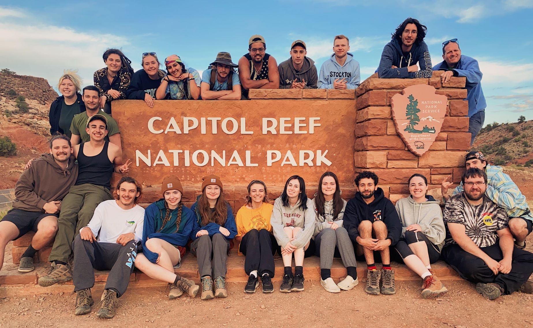 Stockton students, staff and faculty pose for a group photo in front of the entrance sign to Capitol Reef National Park as part of the Geology Club's two week trip.