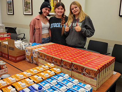 Student volunteers next to the "production line" of food for the meal kits