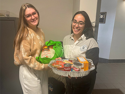 Student recieving one of the donated meal kits and turkey