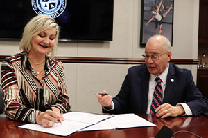 Karen Alton and Harvey Kesselman sign agreement