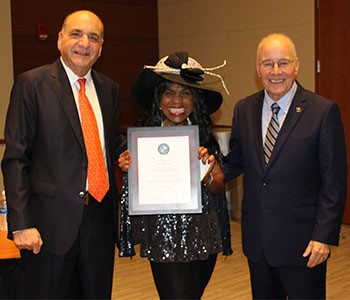 Beverly Vaughn, center, receives an award from Ray Ciccone and Harvey Kesselman