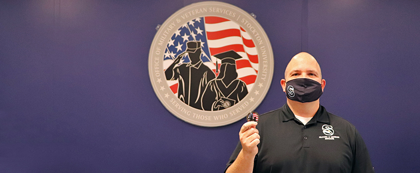 Director of the Office of Military and Veteran Services Jason Babin holds a Stockton challenge coin.