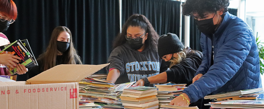 Volunteers sort through nearly 1,000 books to be donated to local schools at Stockton University's 18th Annual MLK Day of Service.