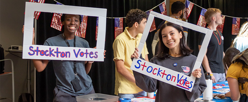 Stockton University students take a break checking their peers' voter registration status to pose for a photo. Efforts like these have led to high student voter participation numbers.