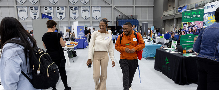 Two students browsing tables at the Career Fair. 