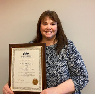 Gina Maguire holding award.