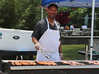 Cheesesteak Mike of Chartwells grilling burgers and hot dogs