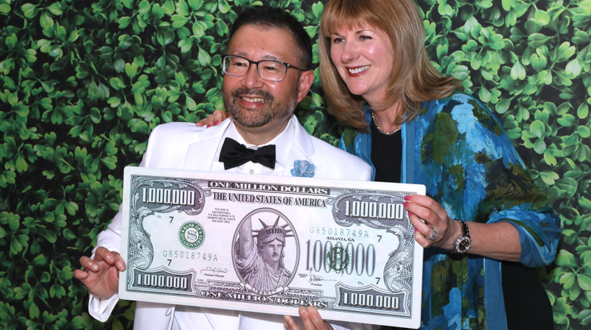 Guests of the Scholarship Benefit Gala posing with a fake million dollar bill.