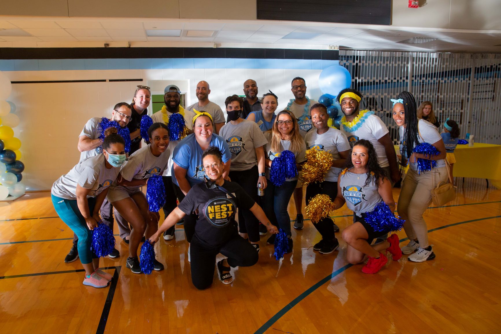 Staff members from various departments at Stockton University pose with big smiles for the camera during the Summer Slam event, part of Stockton's new overnight orientation experience called Nest Fest.