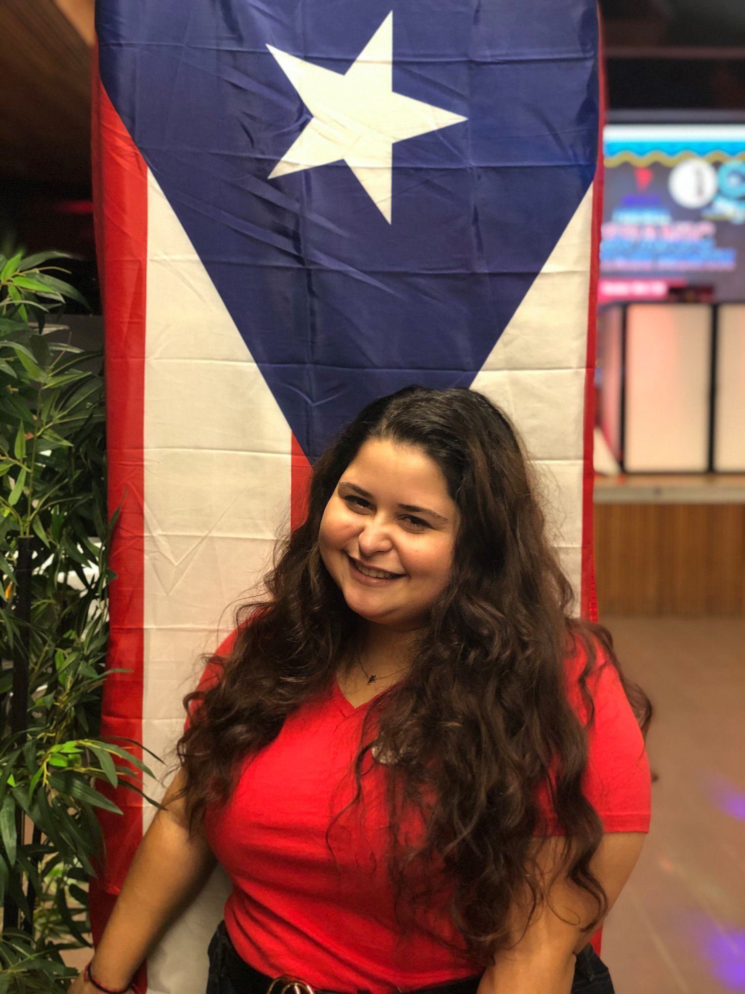 Kiara Padilla in front of the Puerto Rican flag