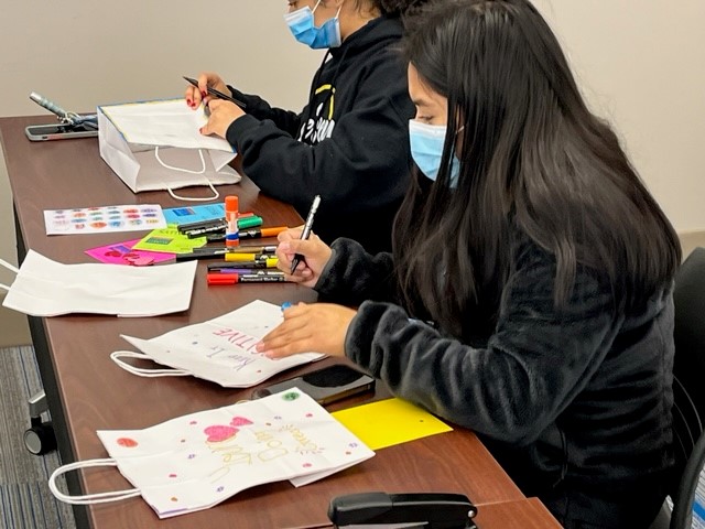 Students decorate white paper bags with markers that will be filled with personal care items and donated to the Atlantic City Rescue Mission as part of the 18th Annual MLK Day of Service.