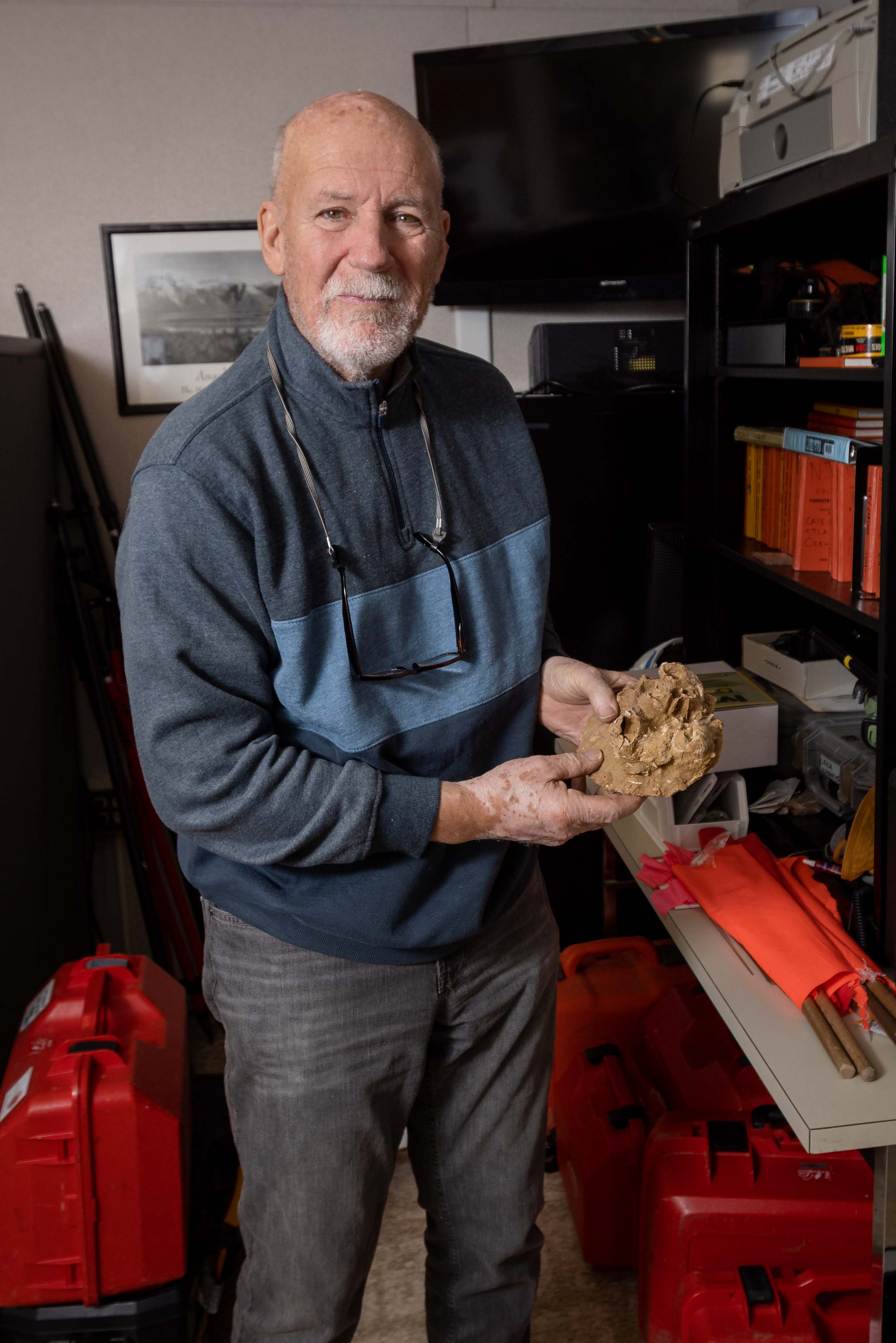 Stewart Farrell holds a fossilized barnacle in the Coastal Research Center
