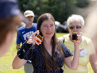 Judith Vogel of the Maple Project holding syrup, talking to campers