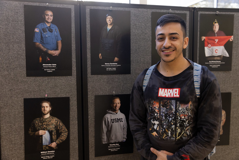 Student veteran in front of his portrait