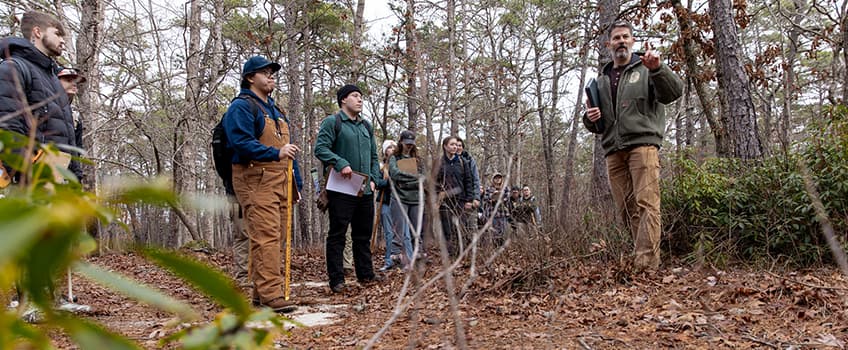 Environmental science students and Dr. Matthew Olson in the forest