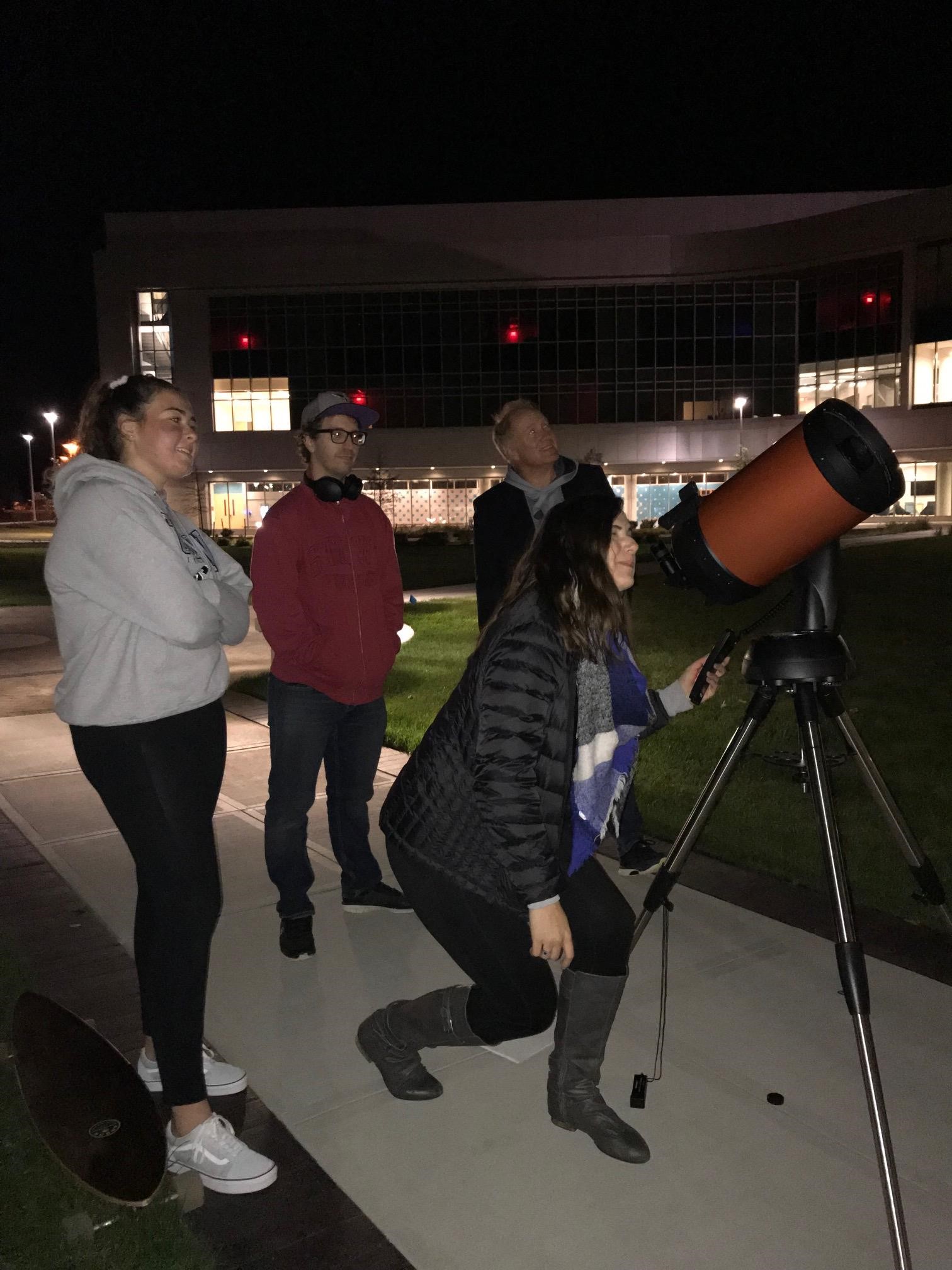 Image of Stockton University students viewing the night sky on campus.