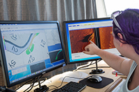 Image of marine science student points to the Bead Wreck on computer screen