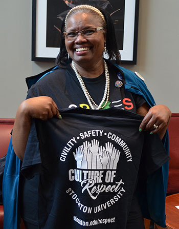 staff holding Culture of Respect t-shirt