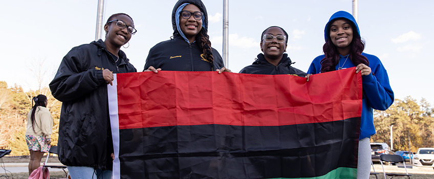 students holding Black history month flag