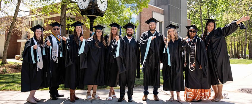 Masters Ceremony Graduates pose and smile outside