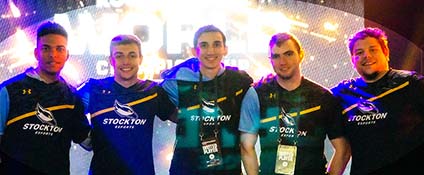 Rocket League team members and coach pose in front of bright gaming screen
