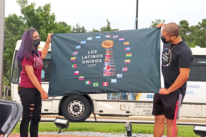 Two students hold a Los Latinos Unidos flag