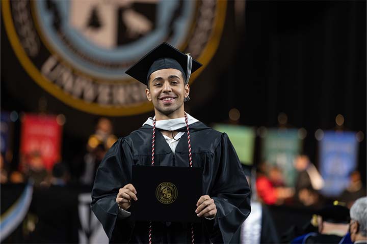 A proud graduate shows off his diploma cover