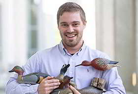 Photo of Cooper Rossner and his decoy carvings