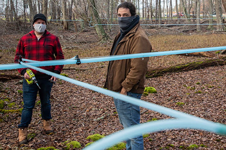 Research assistant Joseph Russell, left, and Aaron Stoler, assistant professor of Environmental Science, set up a tubing system that connects the maple trees so that sap can be collected in one central location.