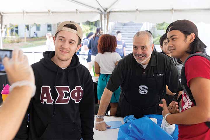 Joe Bertolino (center) poses with two male students at an ice cream social