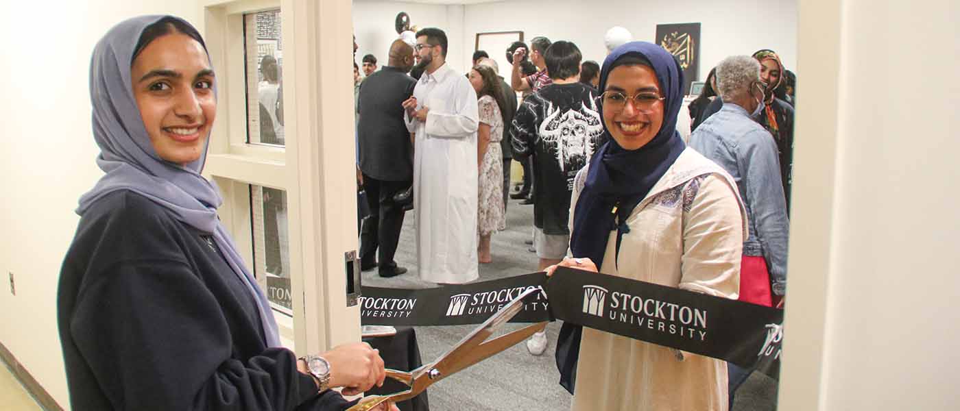 Two female Muslim students cut a Stockton ribbon to open the meditation room