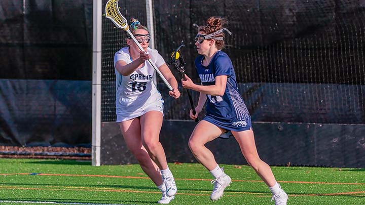 Kerstin Axe playing lacrosse against one defender